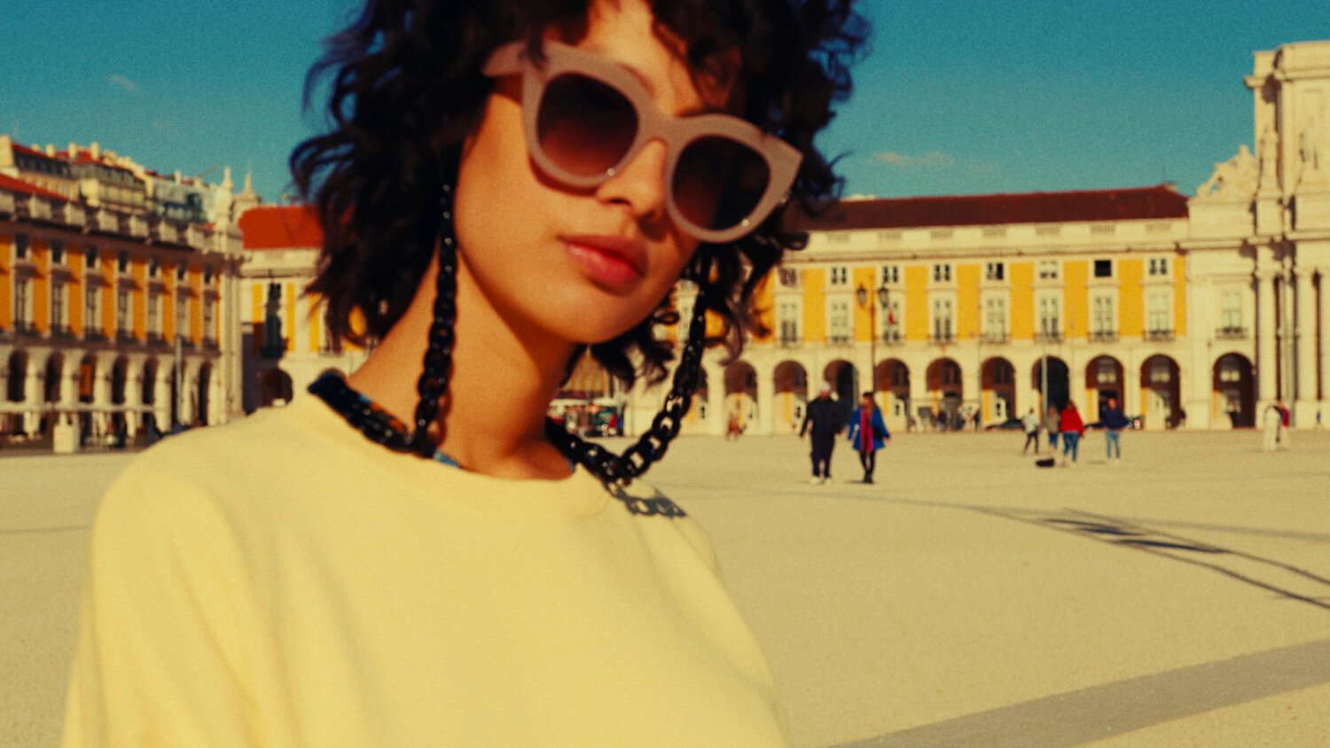 Hush Spring Lisbon Film thumbnail showing model in Lisbon square with vibrant colour and sunlight