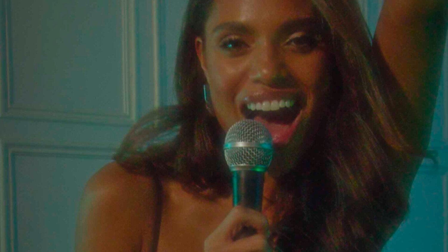 Lipsy Christmas Dinner Film scene with woman singing into microphone during festive dinner gathering