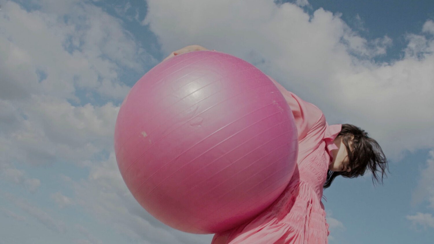 Stella Magazine Editorial Film thumbnail showing model with pink ball on beach under blue sky